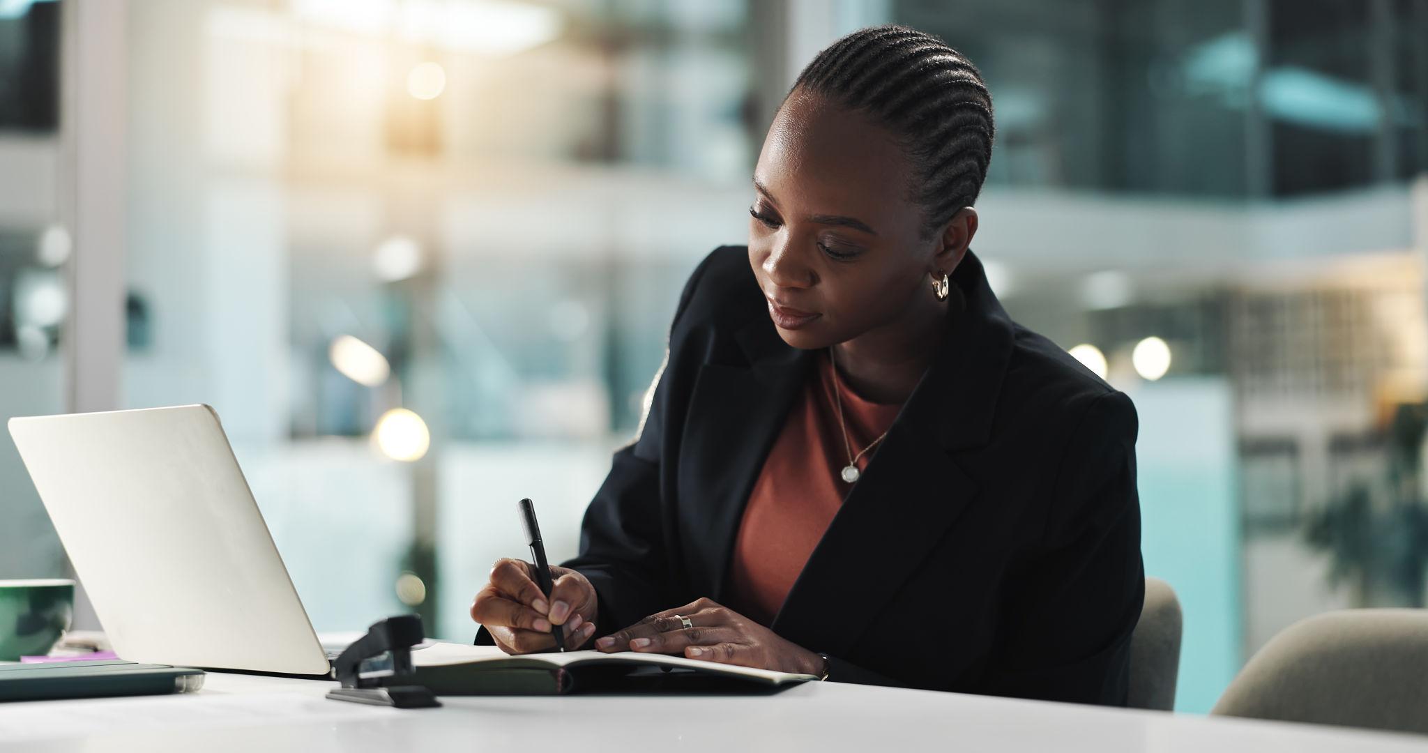 Woman taking notes at a desk during a working session